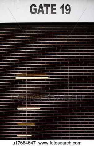 Stock Photo - Close-up of 'GATE 19' sign on ceiling. Fotosearch