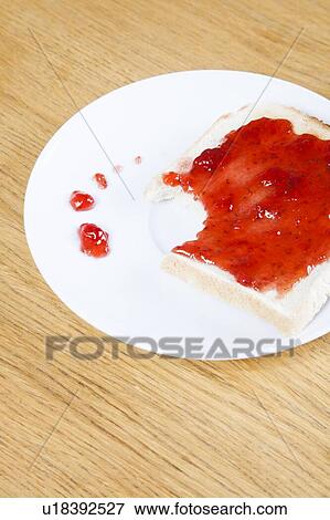 Stock Photo - Close-up of jam spread on slice of bitten bread. Fotosearch