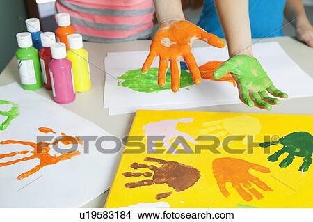 Close-up of paint covered hands and colorful handprints on papers View Large Photo Image Picture - Close-up of paint covered hands and colorful handprints on papers. Fotosearch