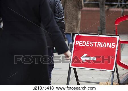 Stock Photo - Close-up of pedestrians arrow sign on sidewalk. Fotosearch