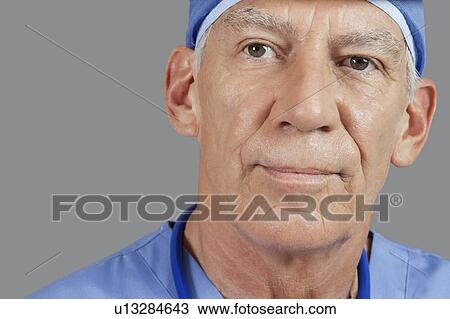 Close-up of senior male doctor over gray background View Large Photo Image Stock Image - Close-up of senior male doctor over gray background. Fotosearch
