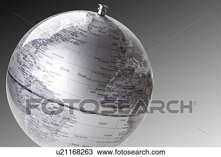 Stock Image - Close-up of silver globe over gray background. Fotosearch