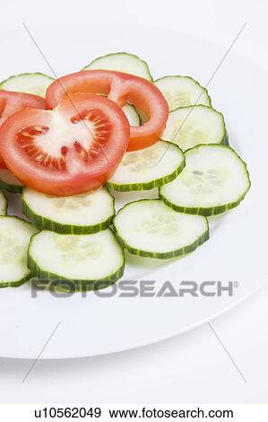 Stock Photo - Close-up of sliced tomatoes and cucumbers in plate. Fotosearch