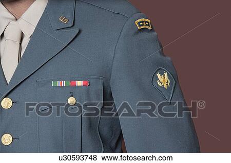 Stock Photo - Close-up of US military officer's uniform with badge over brown background. Fotosearch
