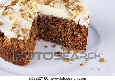 Stock Image - Close-up of walnut cake in plate over white background. Fotosearch