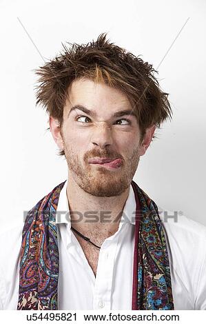 Close-up of young man making a face against white background View Large Photo Image Stock Image - Close-up of young man making a face against white background. Fotosearch