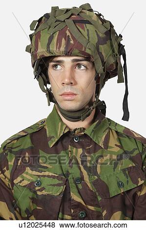 Close-up of young soldier against gray background View Large Photo Image Stock Photo - Close-up of young soldier against gray background. Fotosearch