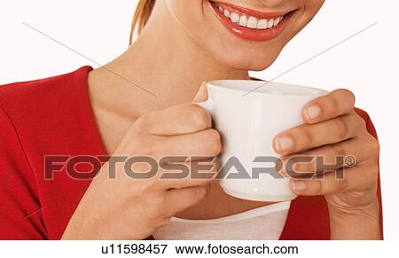 Stock Photo - Close up on woman drinking a cup of tea in studio. Fotosearch