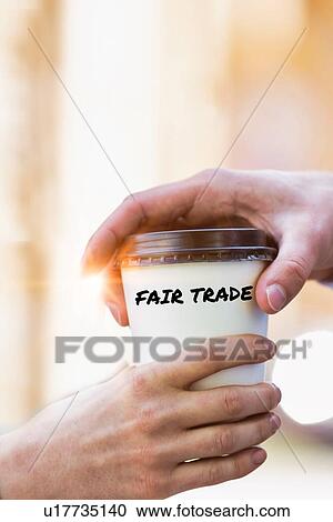 Stock Image - Close up photo of businesswoman giving businessman a cup of fair trade coffee . Fotosearch