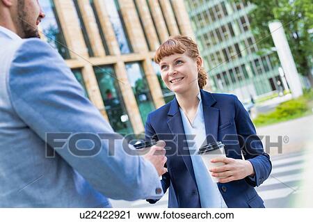 Close up photo of businesswoman giving businessman a cup of coffee View Large Photo Image Stock Image - Close up photo of businesswoman giving businessman a cup of coffee. Fotosearch