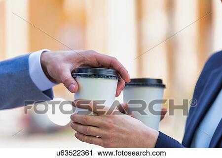 Close up photo of businesswoman giving businessman a cup of coffee View Large Photo Image Stock Image - Close up photo of businesswoman giving businessman a cup of coffee. Fotosearch