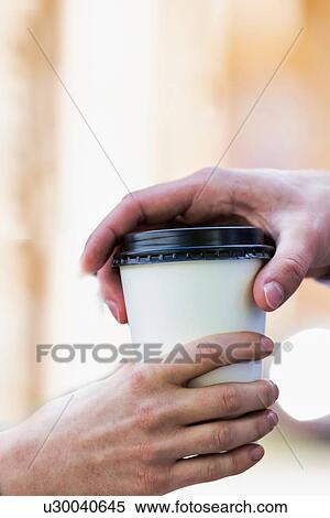 Close up photo of businesswoman giving businessman a cup of coffee View Large Photo Image Stock Photography - Close up photo of businesswoman giving businessman a cup of coffee. Fotosearch