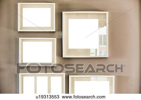 Stock Image - Close up photo of picture frames on the wall in new apartment. Fotosearch