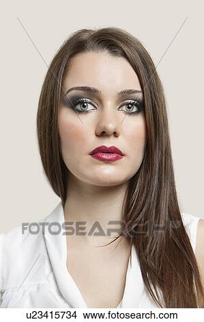 Picture - Close-up portrait of a beautiful young woman over gray background. Fotosearch