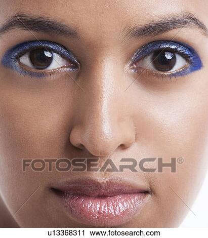 Close-up portrait of beautiful young woman with blue eyeshadow against white background View Large Photo Image Stock Image - Close-up portrait of beautiful young woman with blue eyeshadow against white background. Fotosearch