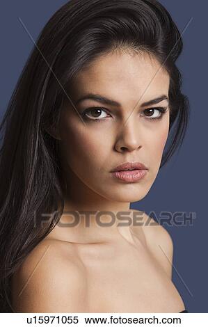 Close-up portrait of beautiful young woman over blue background View Large Photo Image Stock Photography - Close-up portrait of beautiful young woman over blue background. Fotosearch