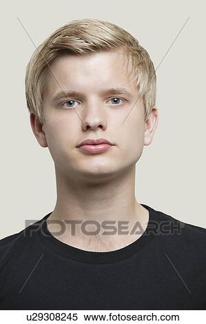 Close-up portrait of serious young man against gray background View Large Photo Image Stock Photography - Close-up portrait of serious young man against gray background. Fotosearch