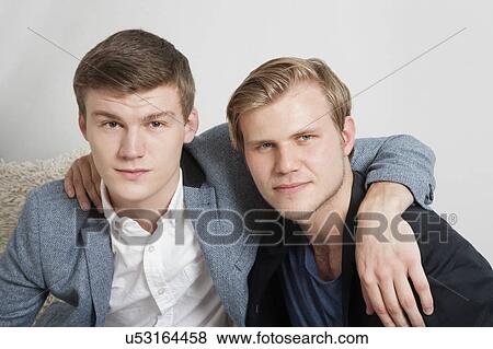 Close-up portrait of two young male friends with arms around View Large Photo Image Stock Photo - Close-up portrait of two young male friends with arms around. Fotosearch