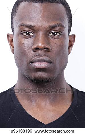 Stock Photograph - Close-up portrait of young African American man against white background. Fotosearch
