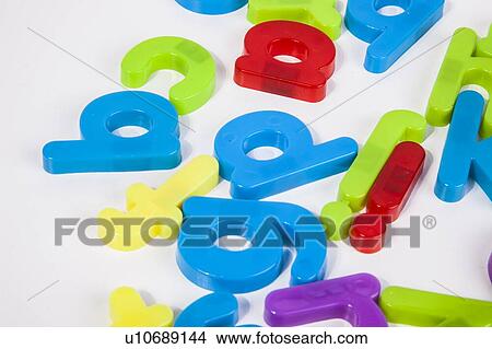 Picture - Close-up view of alphabet magnets scattered over white background. Fotosearch