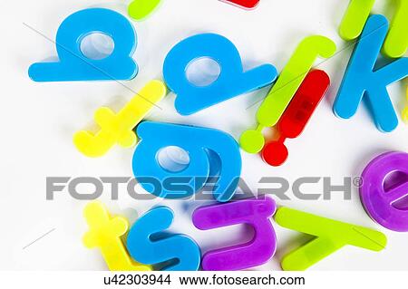 Picture - Close-up view of disordered alphabet magnets on white background. Fotosearch