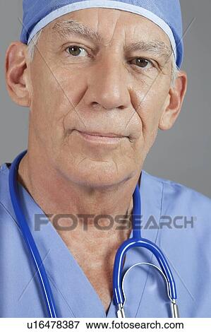 Stock Photo - Close-up view of senior male surgeon over gray background. Fotosearch