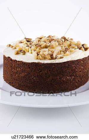 Stock Photograph - Close-up view of walnut cake in plate over white background. Fotosearch