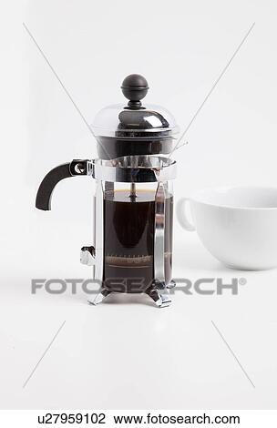 Stock Image - Coffee maker and cup against white background. Fotosearch