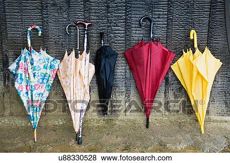 Colorful Umbrellas Leaning Against a Wall View Large Photo Image Stock Photo - Colorful Umbrellas Leaning Against a Wall. Fotosearch