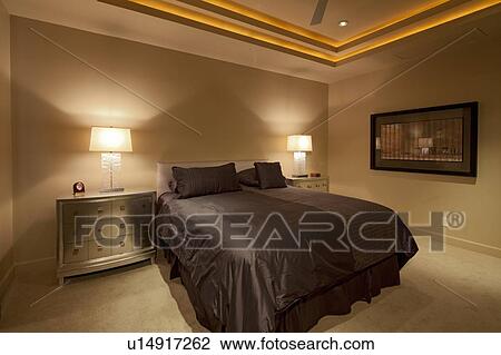 Stock Image - Comfortable bed with lamp on both side in luxury mansion. Fotosearch