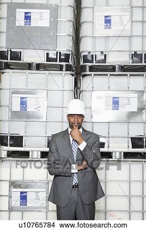 Picture - Confident African American male contractor standing in manufacturing industry. Fotosearch