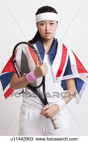 Stock Image - Confident female tennis player with British flag against white background. Fotosearch