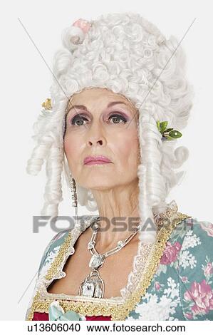 Stock Image - Confident senior queen looking away against gray background. Fotosearch