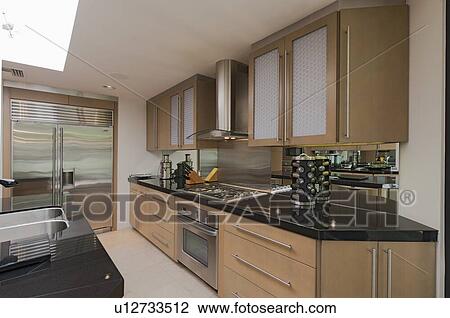 Stock Image - Contemporary kitchen counter and stove in mansion. Fotosearch
