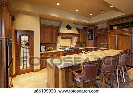 Stock Image - Contemporary kitchen counter with chair in luxury manor house. Fotosearch