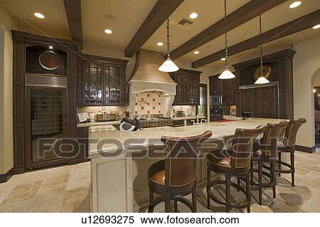 Stock Photography - Contemporary kitchen counter with chair in luxury mansion. Fotosearch