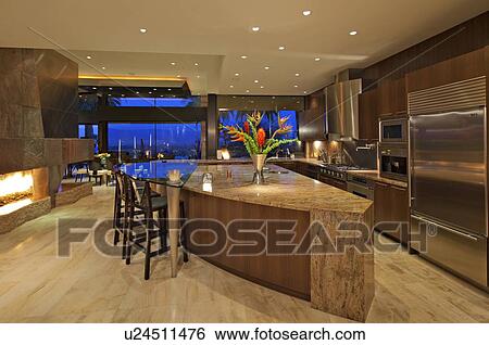Stock Photograph - Contemporary kitchen of manor house under lights. Fotosearch