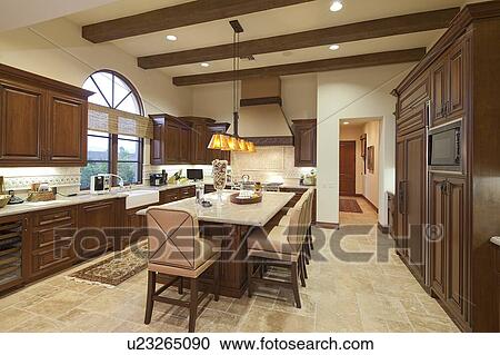 Stock Image - Contemporary kitchen with dining table and chair in luxury villa. Fotosearch