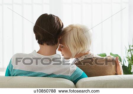 Couple embracing sitting on sofa rear view View Large Photo Image Stock Photo - Couple embracing sitting on sofa rear view. Fotosearch
