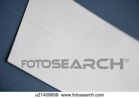 Stock Photo - Cropped image of a blank white paper on dark blue surface. Fotosearch
