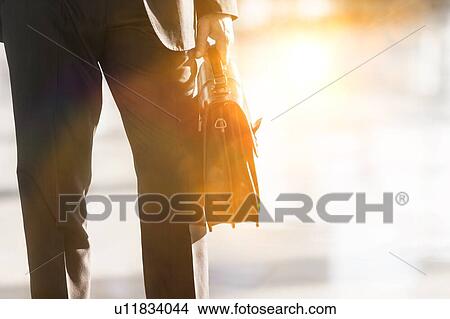 Cropped image of businessman holding briefcase bag in airport View Large Photo Image Picture - Cropped image of businessman holding briefcase bag in airport. Fotosearch