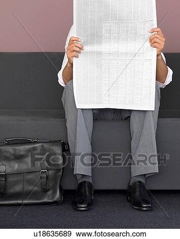 Cropped image of man reading newspaper View Large Photo Image Stock Photo - Cropped image of man reading newspaper. Fotosearch