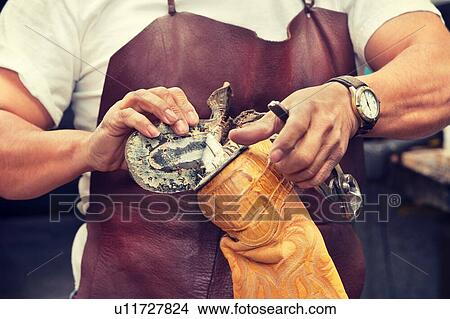 Picture - Cropped image of skilled shoemaker removing sole from boot. Fotosearch
