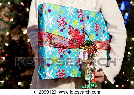 Cropped photo of child holding Christmas Present View Large Photo Image Stock Photo - Cropped photo of child holding Christmas Present. Fotosearch