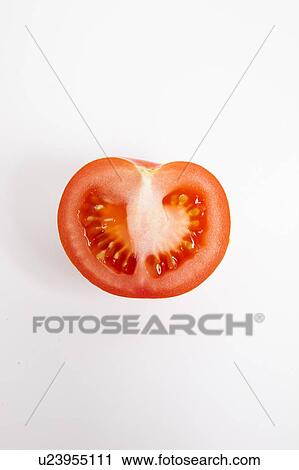 Stock Image - Cross section of tomato over white background. Fotosearch