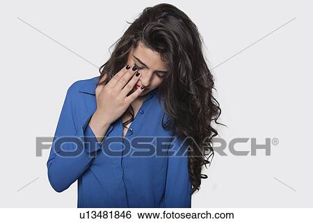 Depressed young woman against gray background View Large Photo Image Stock Photograph - Depressed young woman against gray background. Fotosearch
