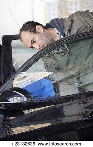 Stock Photography - Employee wiping vehicle window in car wash. Fotosearch