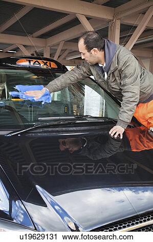 Employee wiping vehicle windscreen in car wash View Large Photo Image Stock Image - Employee wiping vehicle windscreen in car wash. Fotosearch