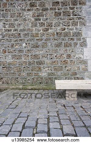 Empty stone bench against a brick wall View Large Photo Image Picture - Empty stone bench against a brick wall. Fotosearch