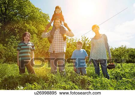 Stock Photography - Family in strawberry field. Fotosearch